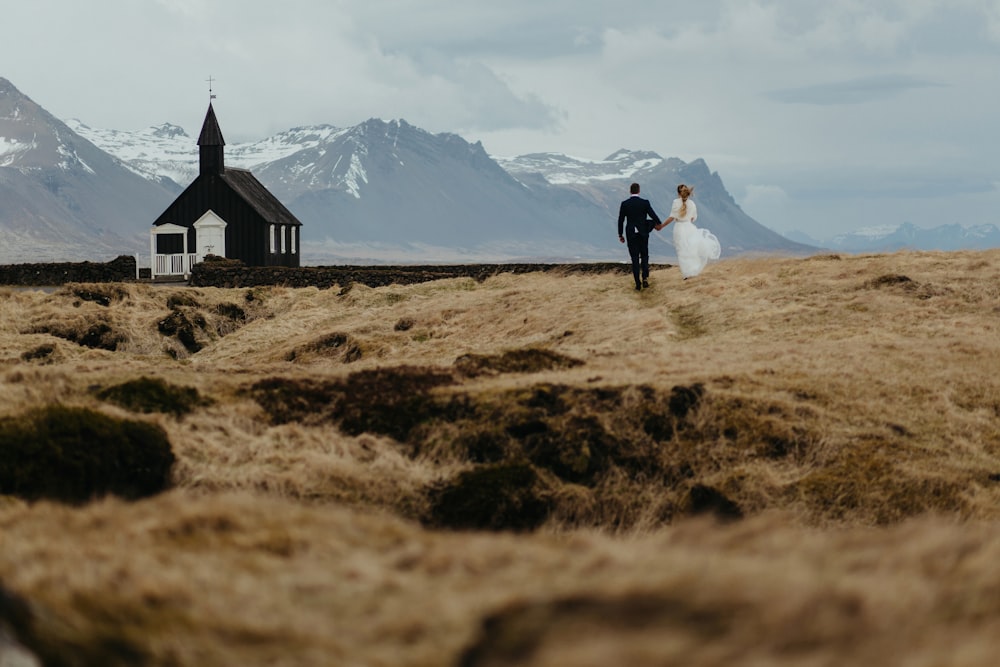 a bride and groom walking towards a church