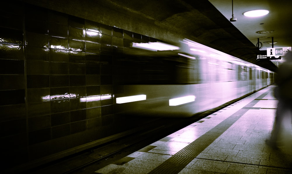 a subway station with a person walking on the platform