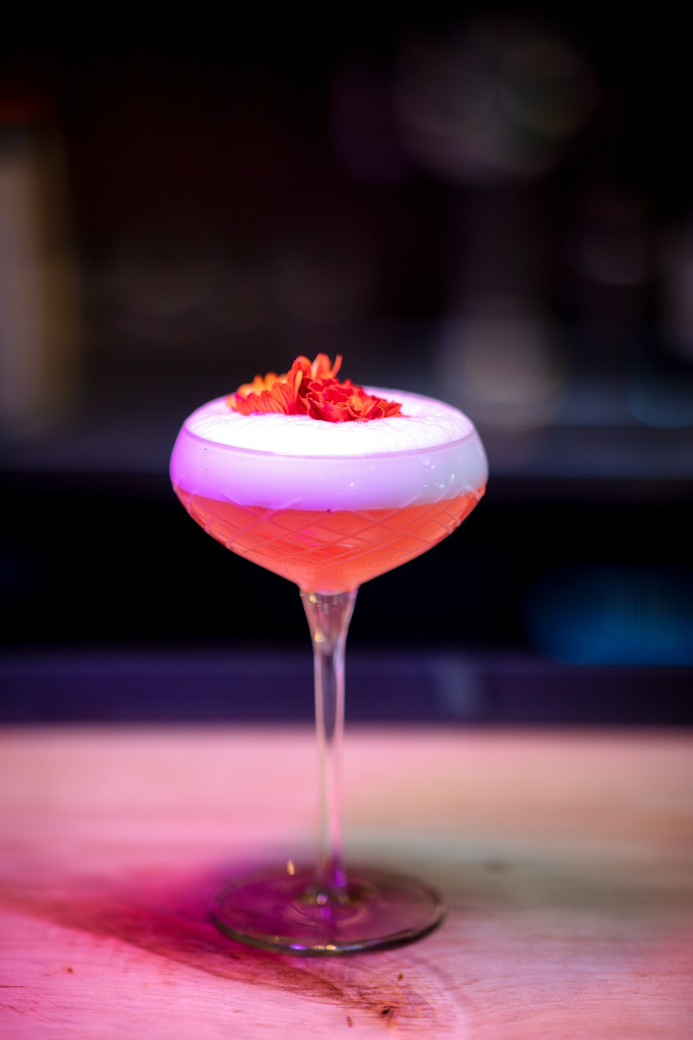 ein rosafarbener Cocktail mit einer garnierenden Garnitur am Rand