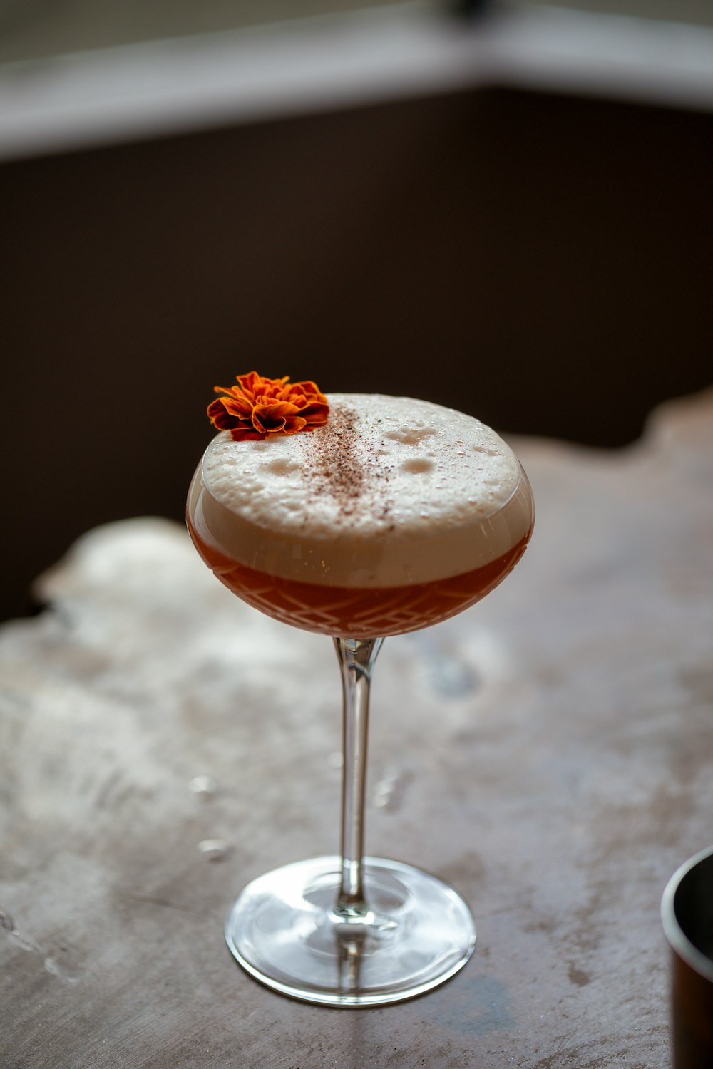 a drink sitting on top of a table next to a cup