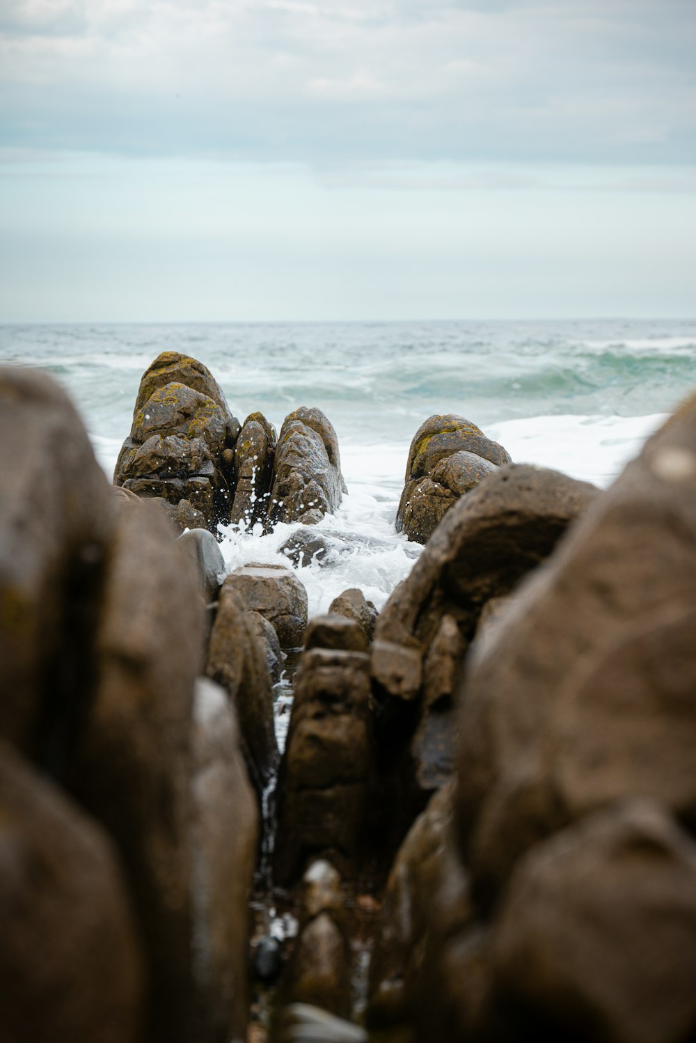 a group of rocks sitting on top of a beach next to the ocean