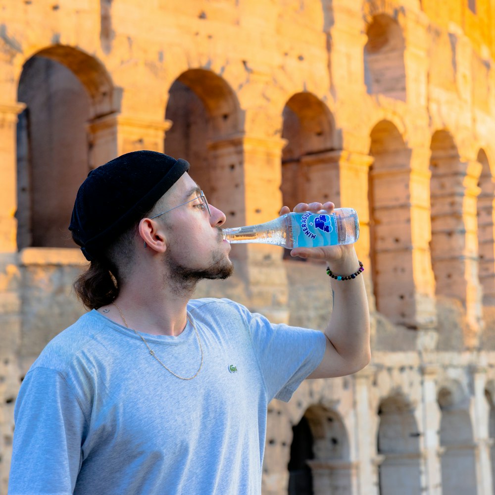 a man drinking water out of a bottle