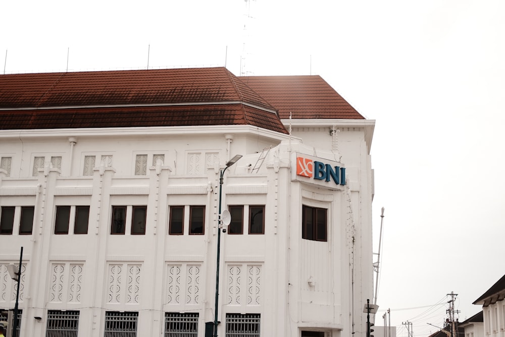 a tall white building with a sign on top of it