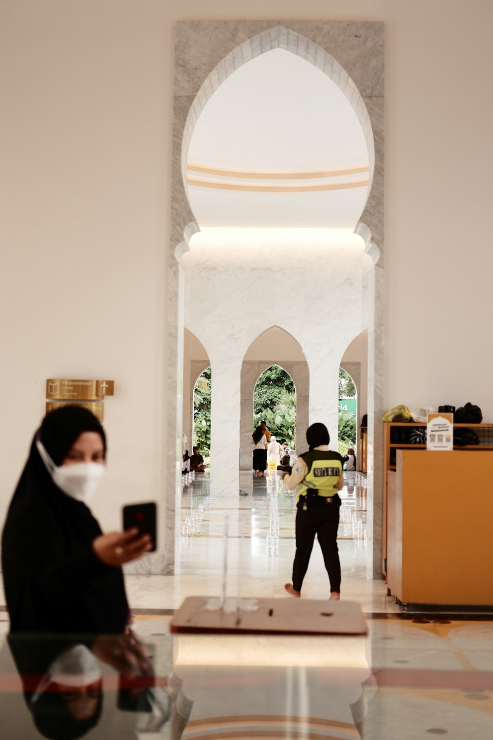 a woman wearing a face mask while looking at her cell phone