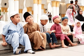 a group of children sitting on a ledge