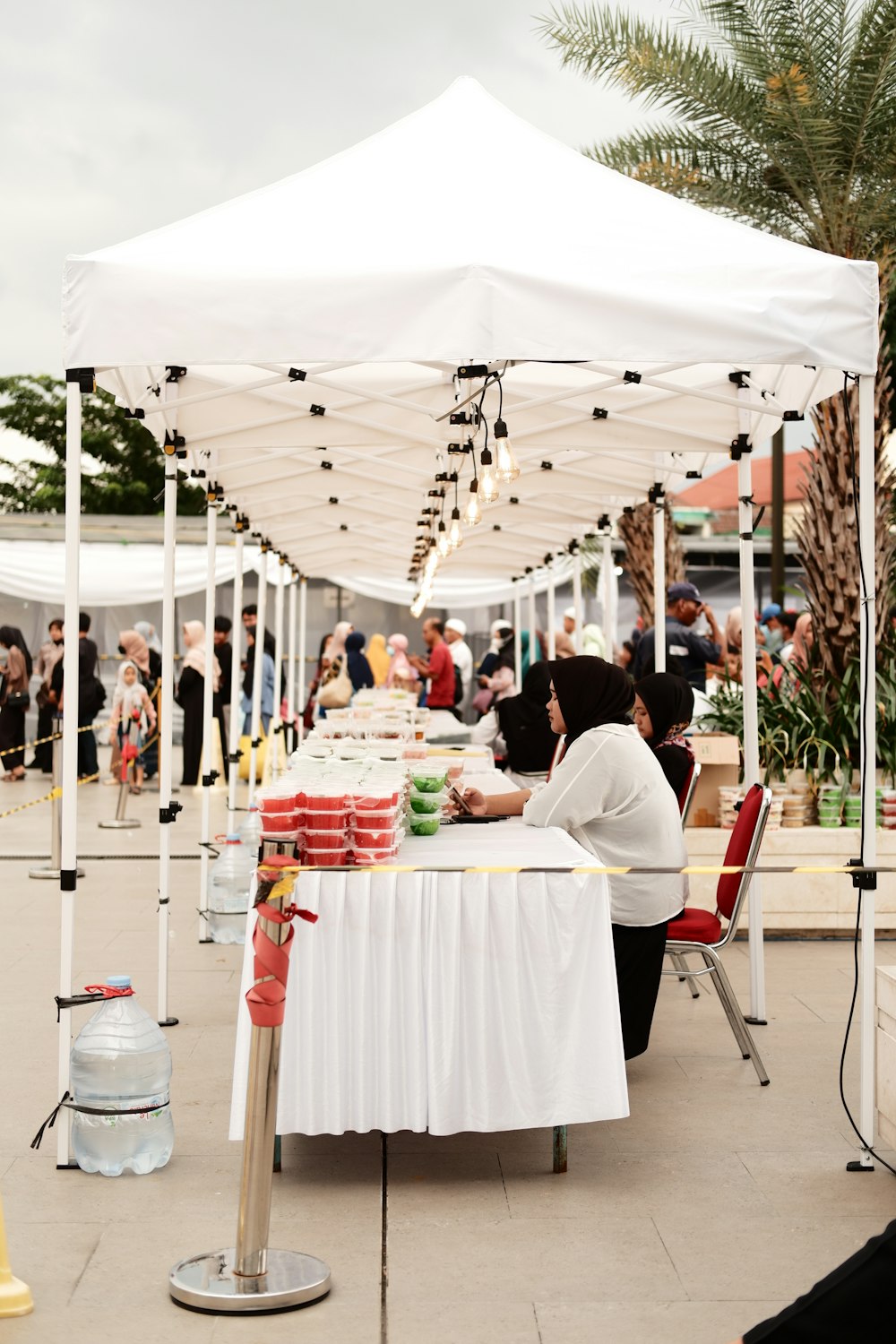 a group of people sitting at a table under a white tent