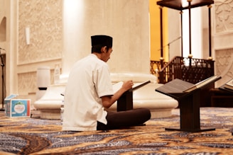 a man sitting on the floor reading a book