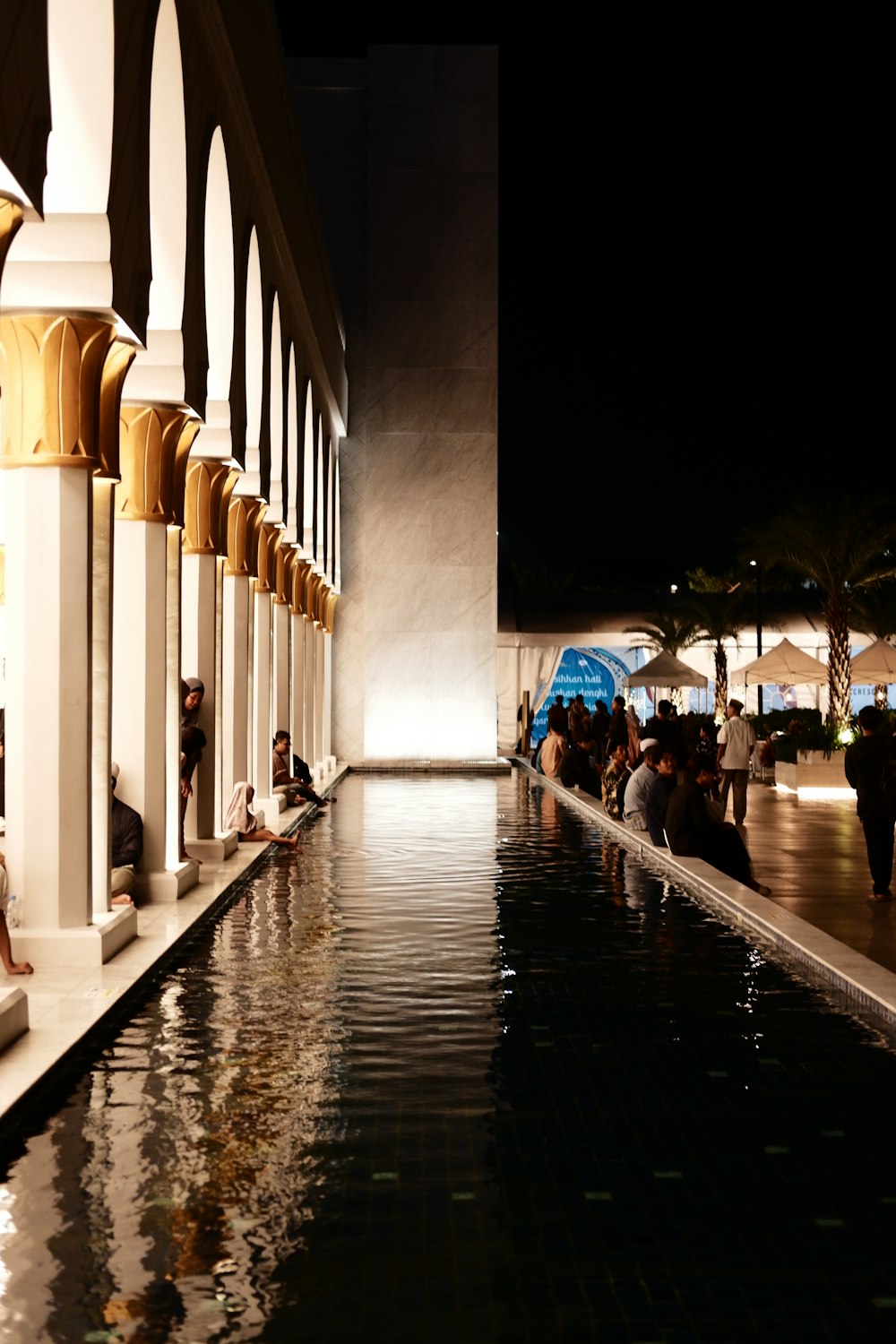 a group of people sitting next to a pool of water