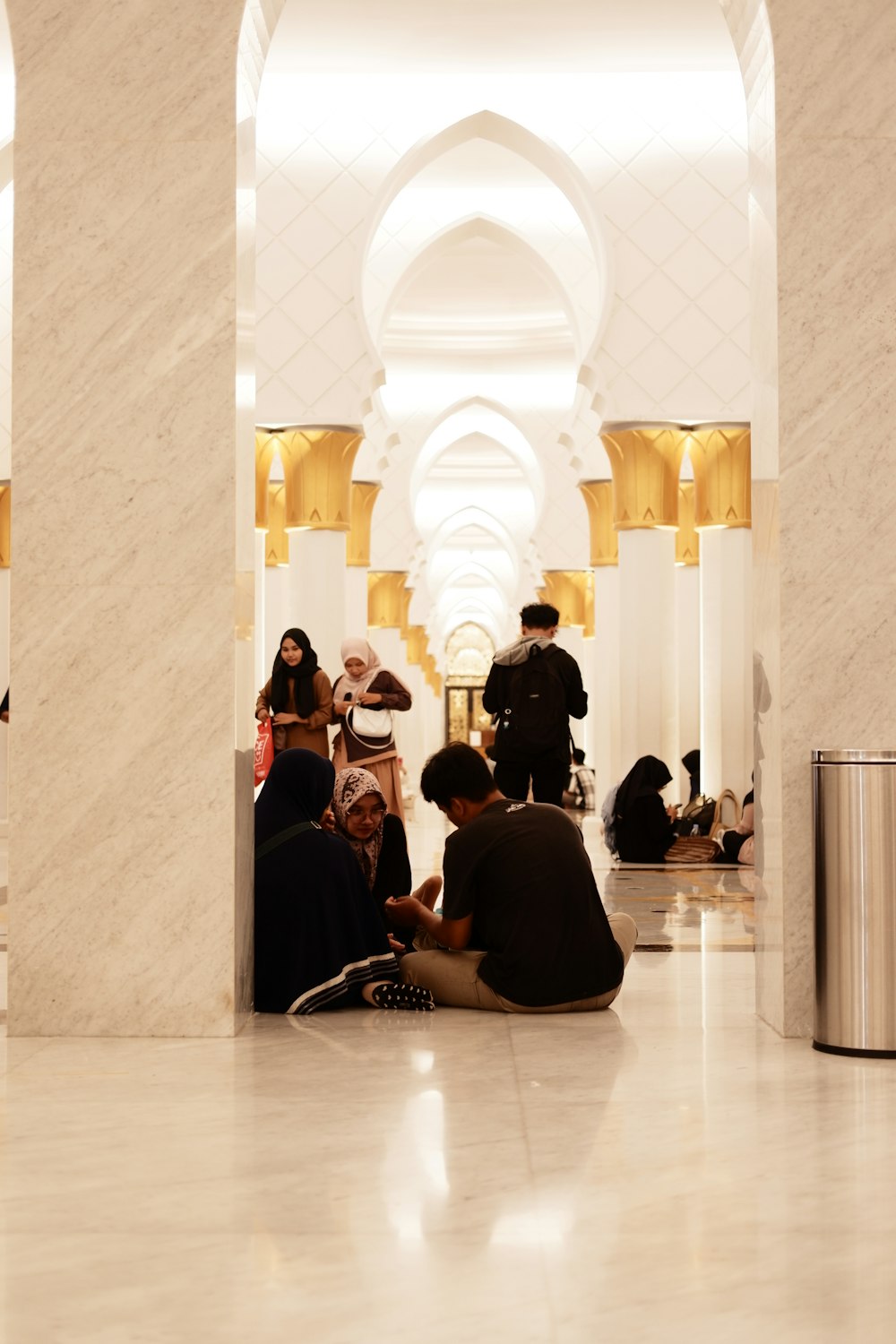 un groupe de personnes assises sur le sol d’un bâtiment