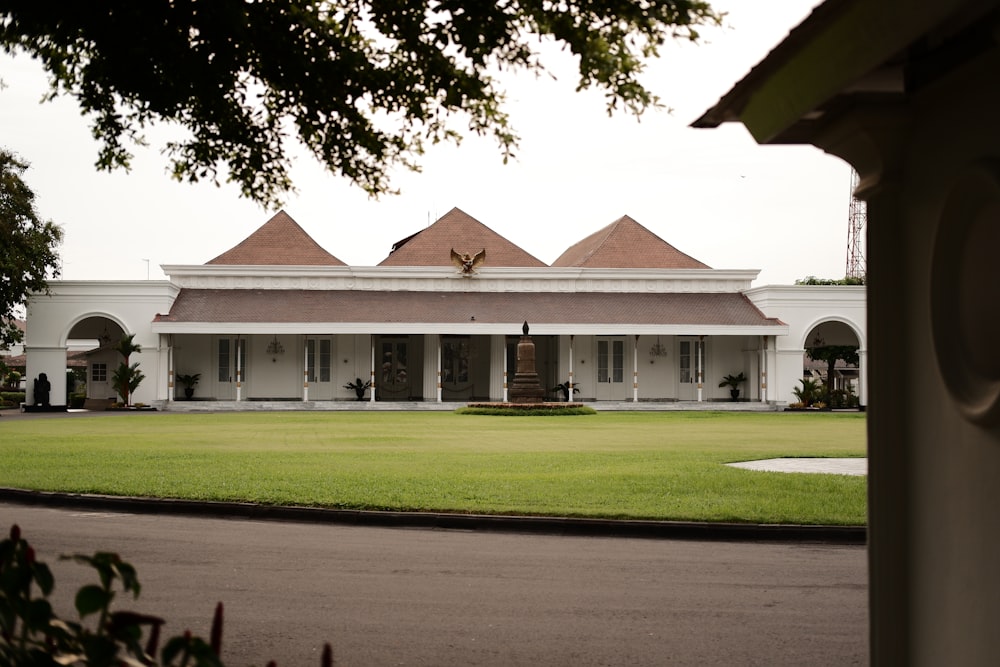 a large white building with a large lawn in front of it