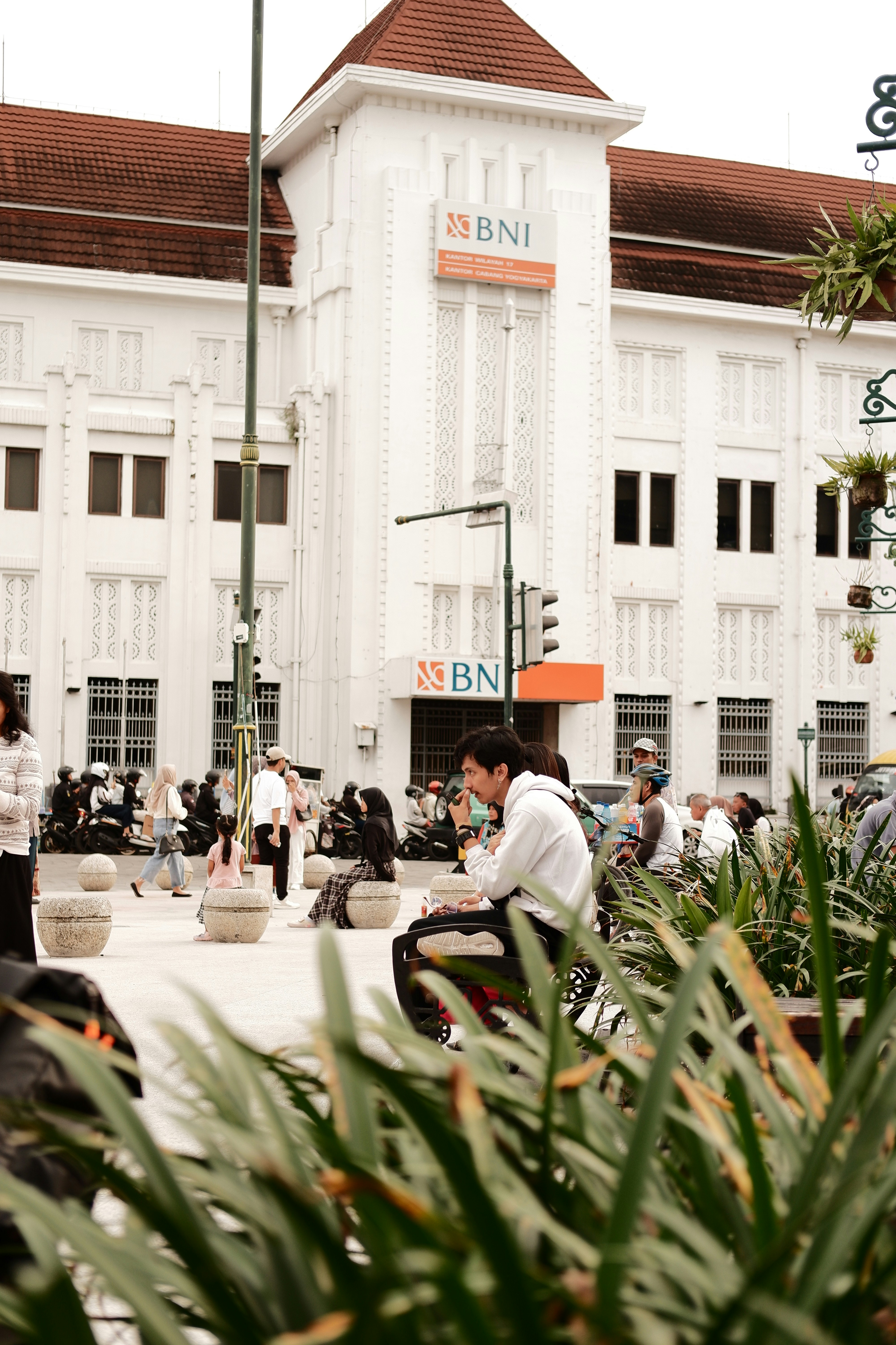 seorang pria duduk di bangku di depan sebuah gedung