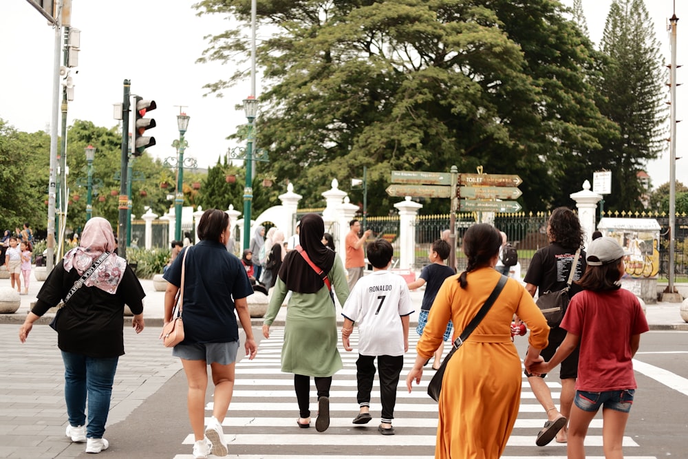 a group of people walking across a cross walk