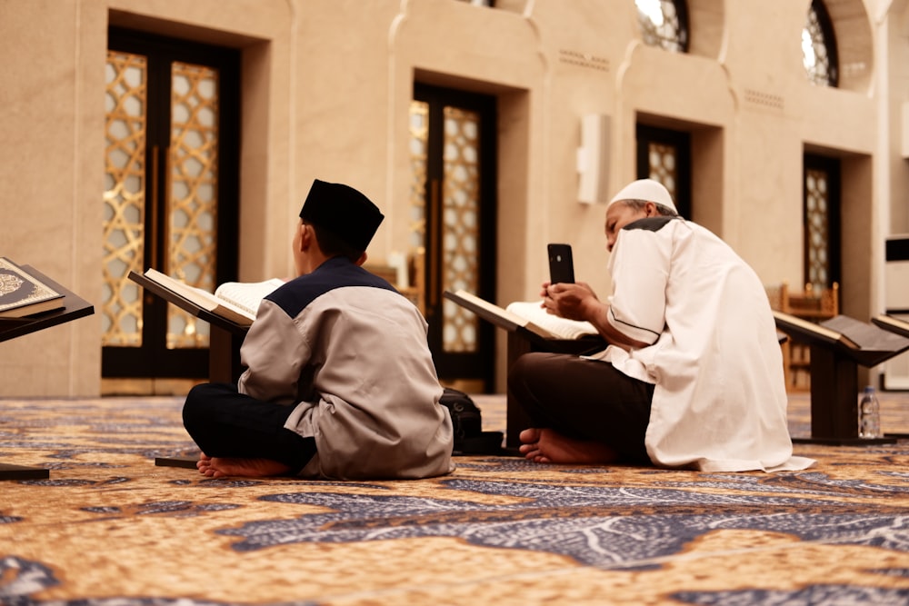 a couple of men sitting on top of a floor