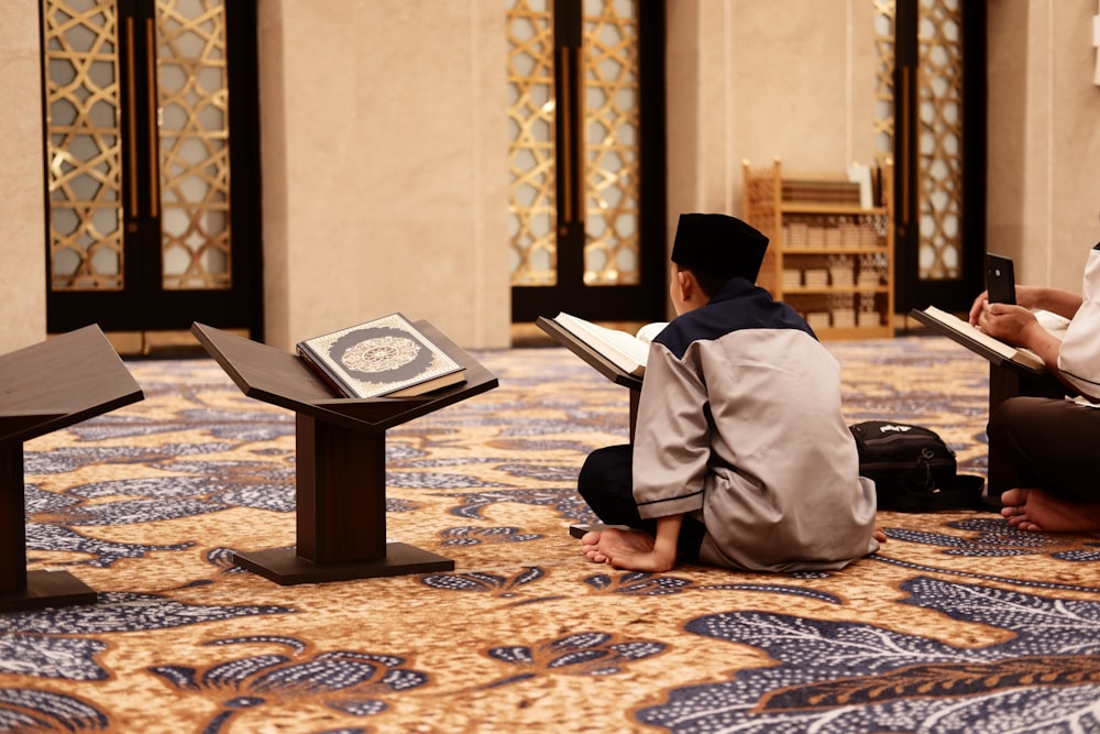 two people sitting on the floor reading books