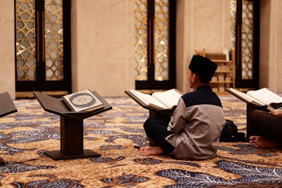 a man sitting on the floor reading a book