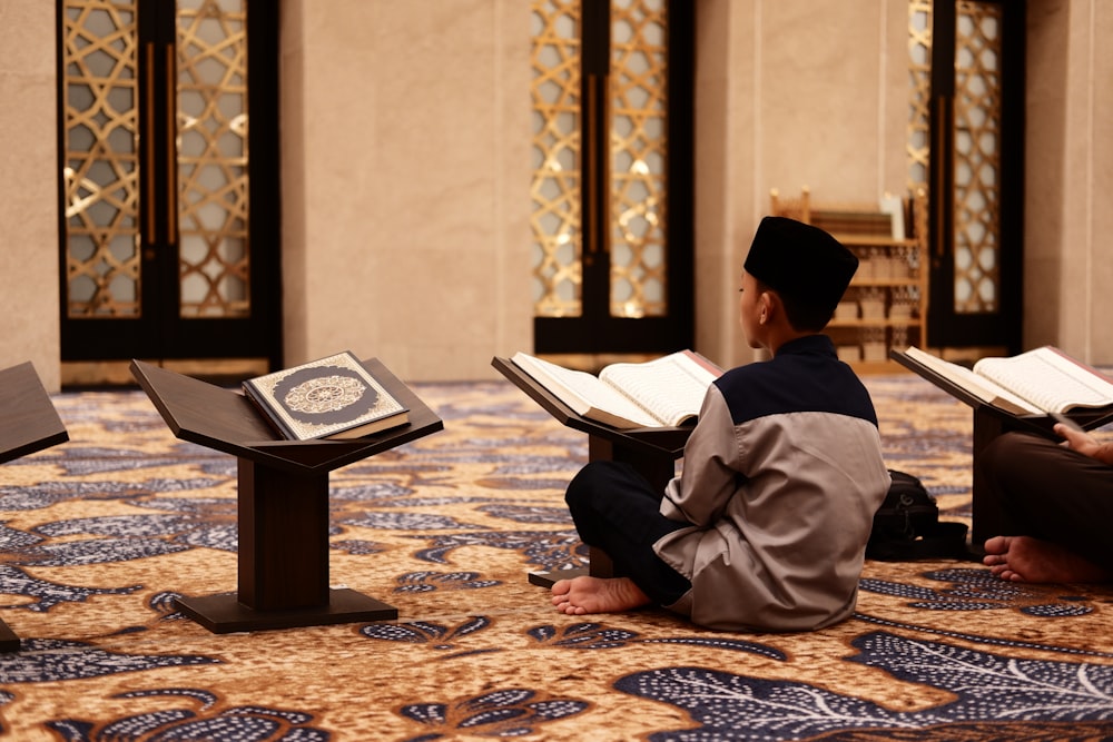 a man sitting on the floor reading a book