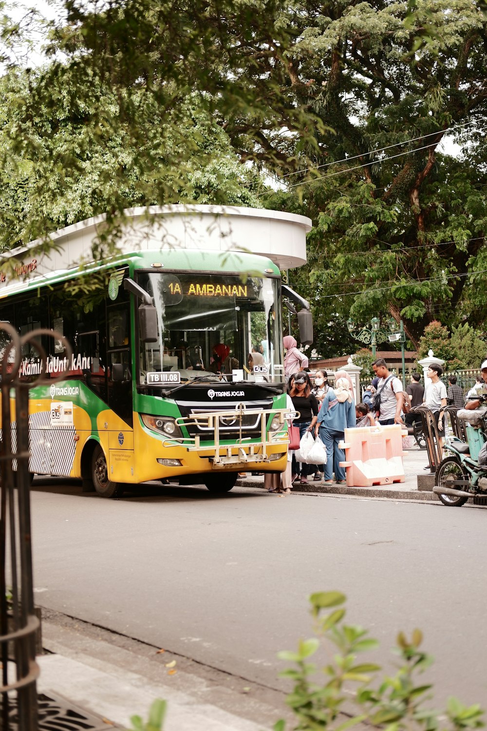ein grün-gelber Bus, der eine Straße entlangfährt