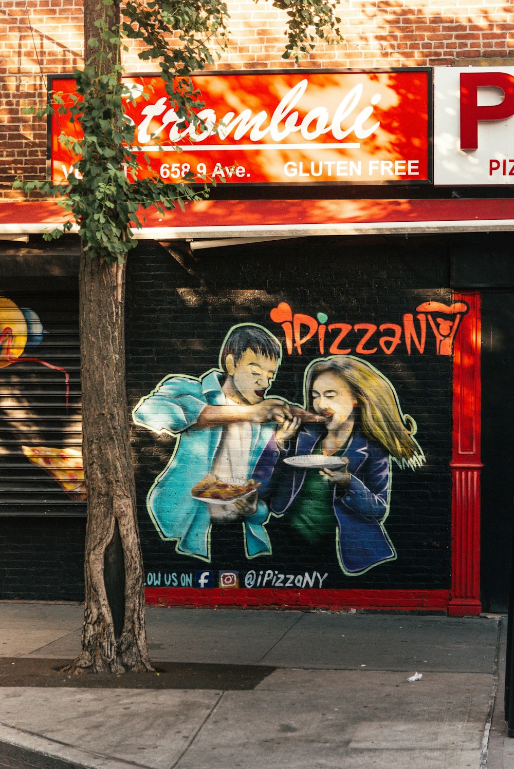 Un mural de un hombre y una mujer comiendo pizza