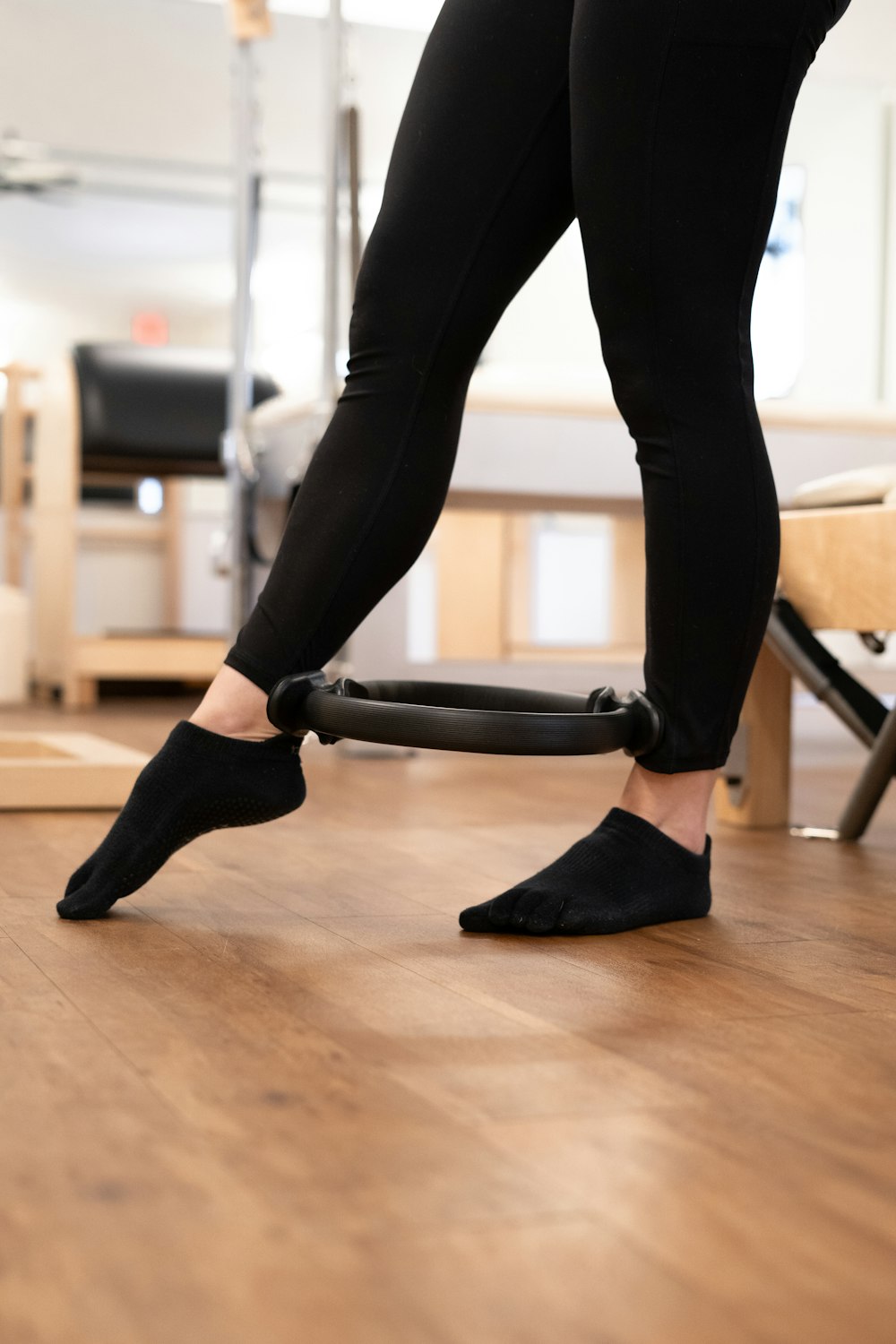 a woman is using a vacuum to clean a wooden floor