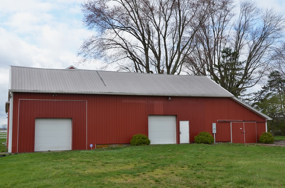 a red barn with two doors and a roof