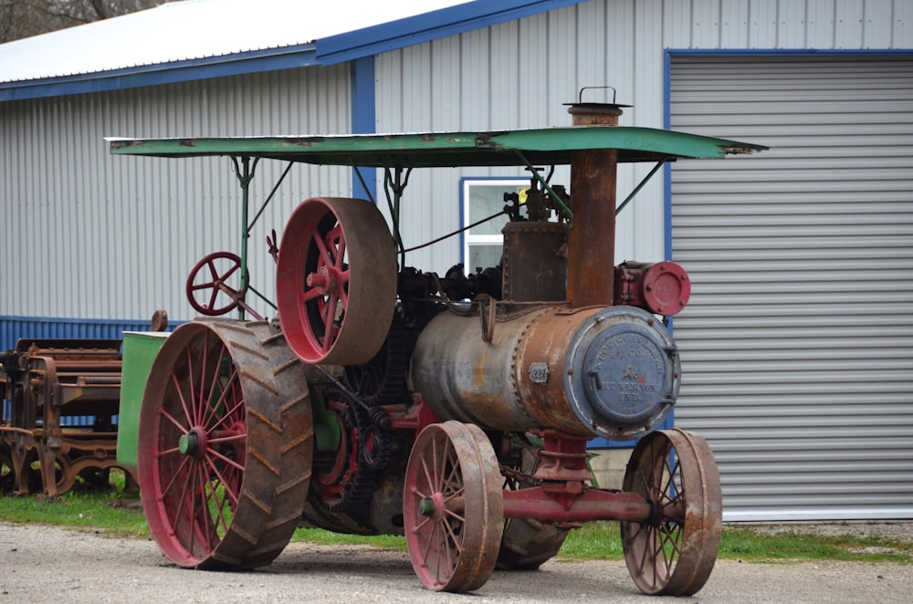 an old fashioned tractor sitting in front of a building