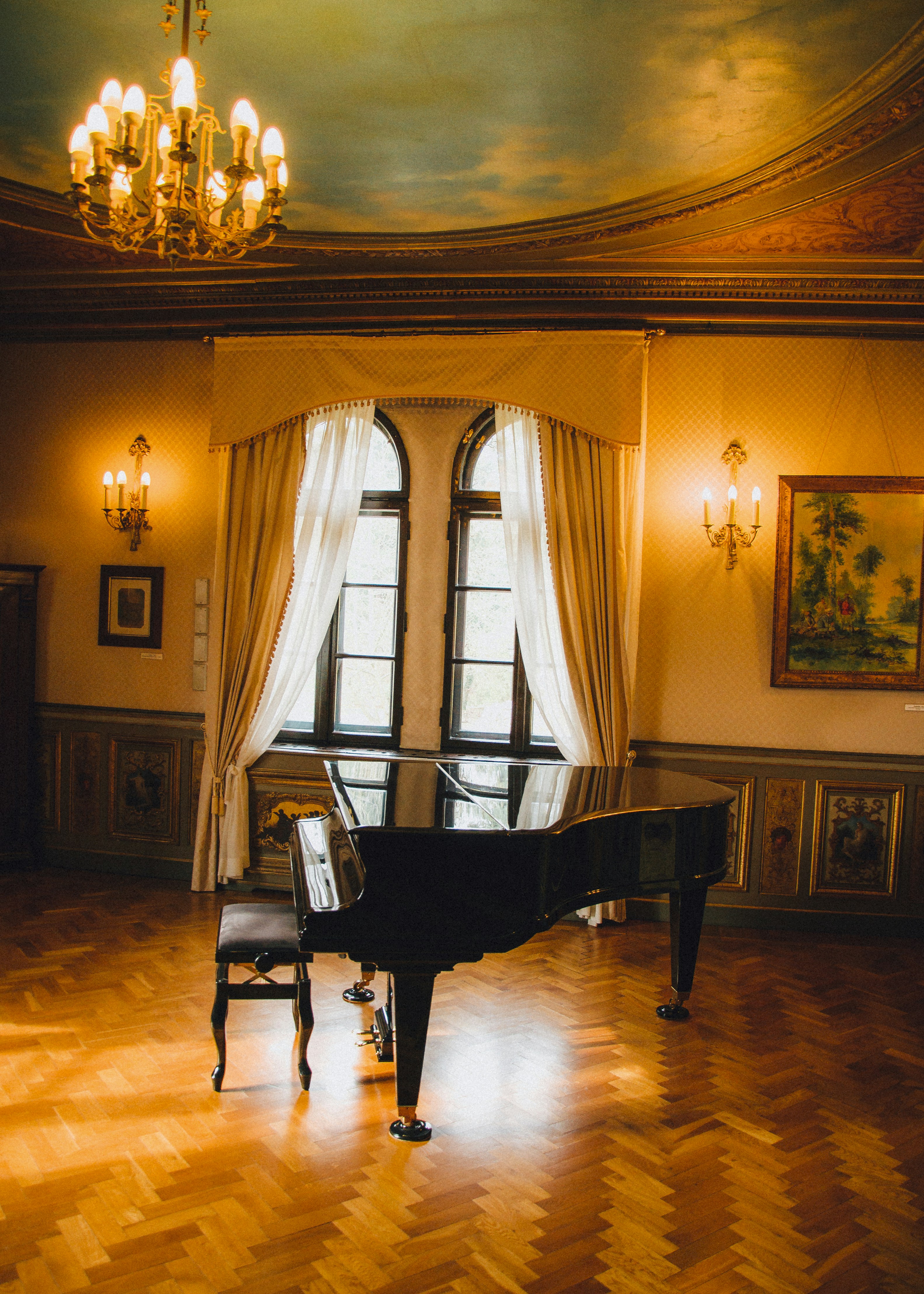 a grand piano in a large room with a chandelier