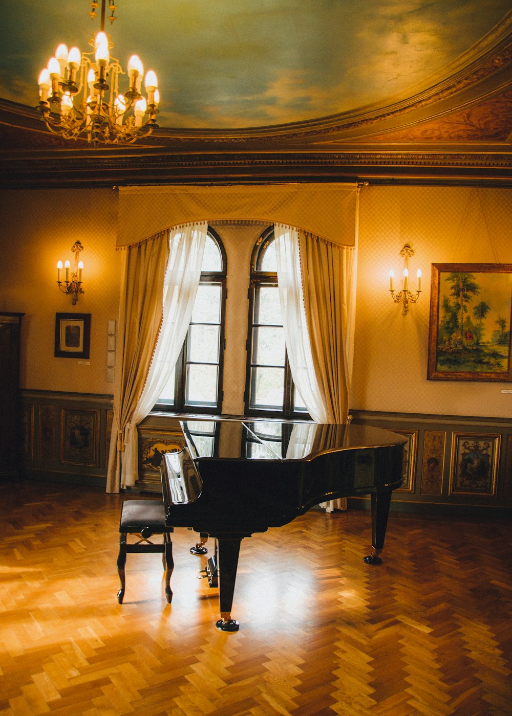 a grand piano in a large room with a chandelier