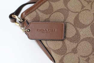 a close up of a brown coach purse