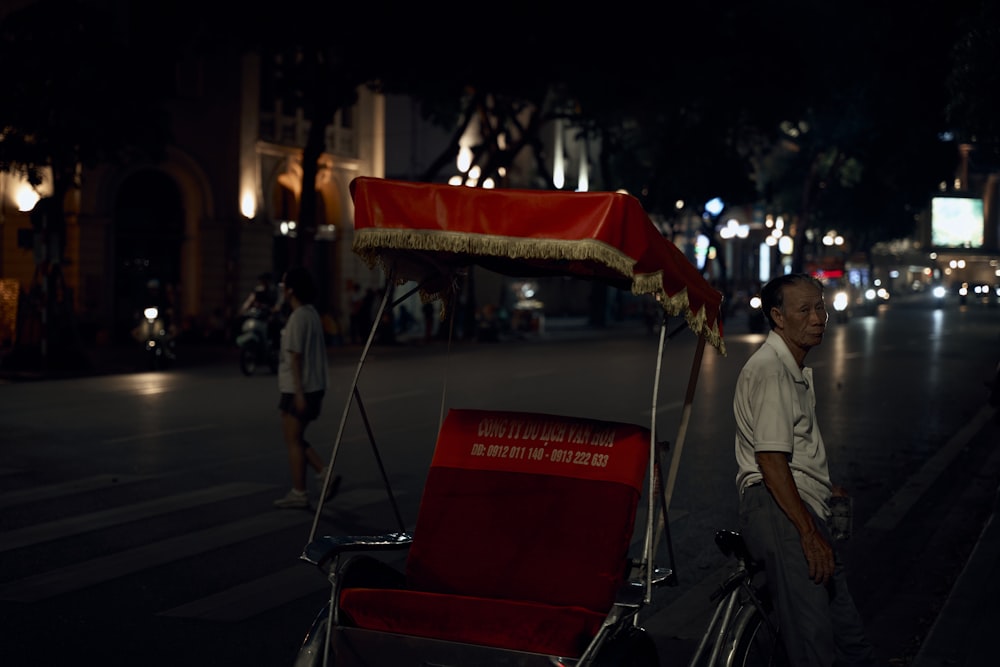a man standing next to a red and white cart