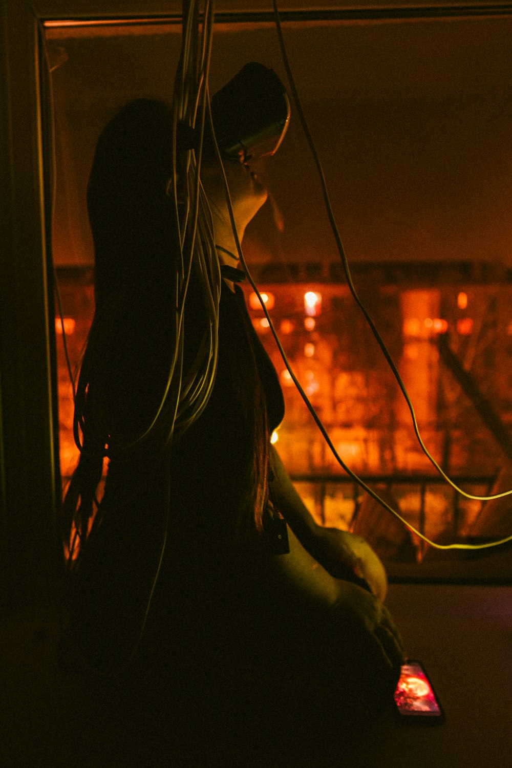 a woman sitting on a window sill looking out a window