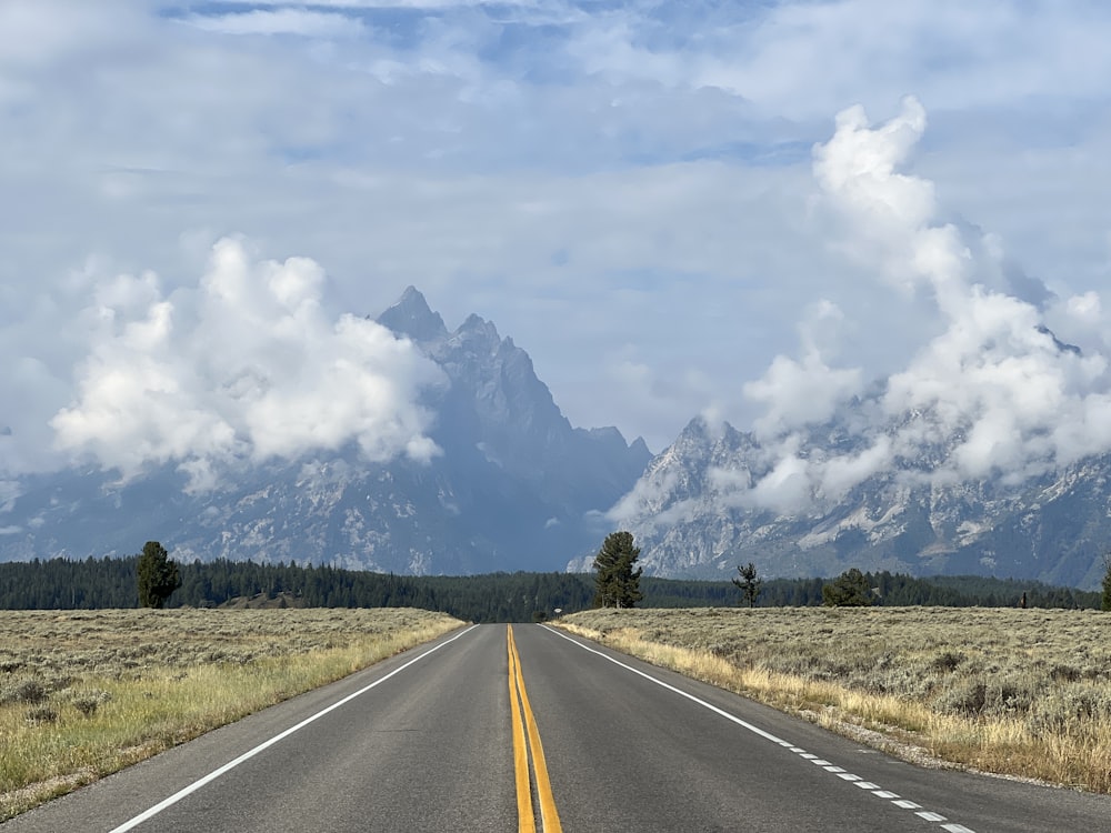 an empty road with mountains in the background