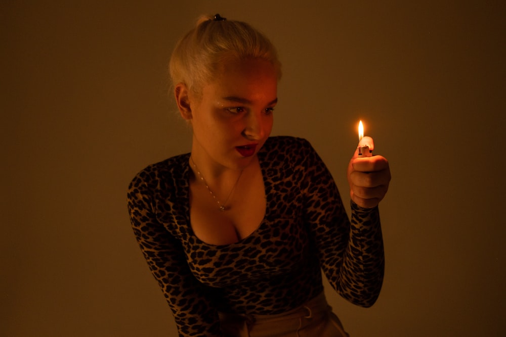 a woman holding a lit candle in her hand