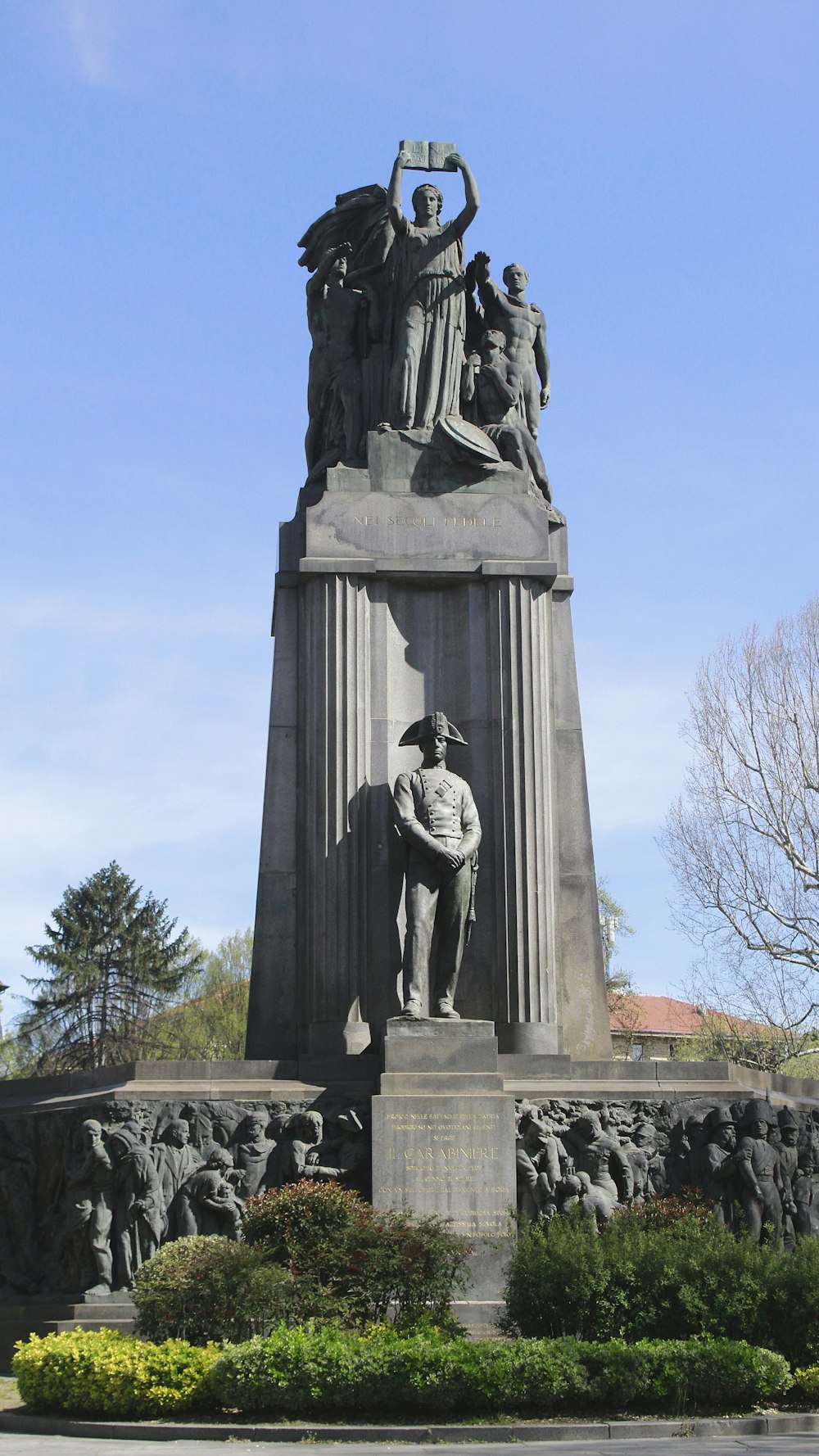 a monument with a statue of a man holding a sword