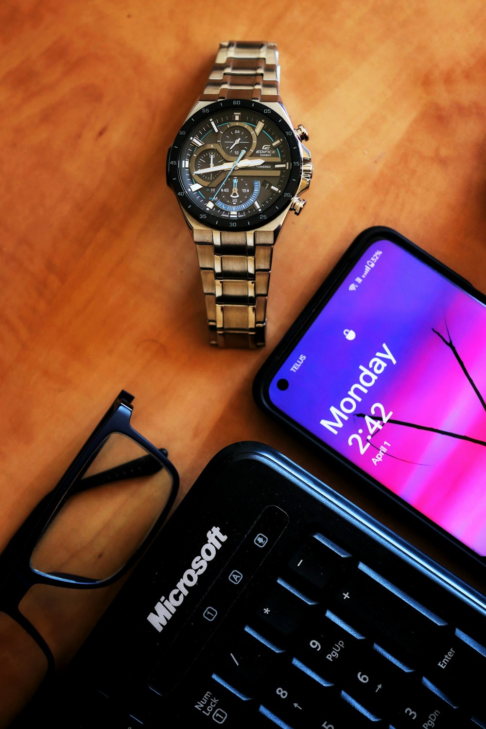 a smart phone sitting next to a watch on a table