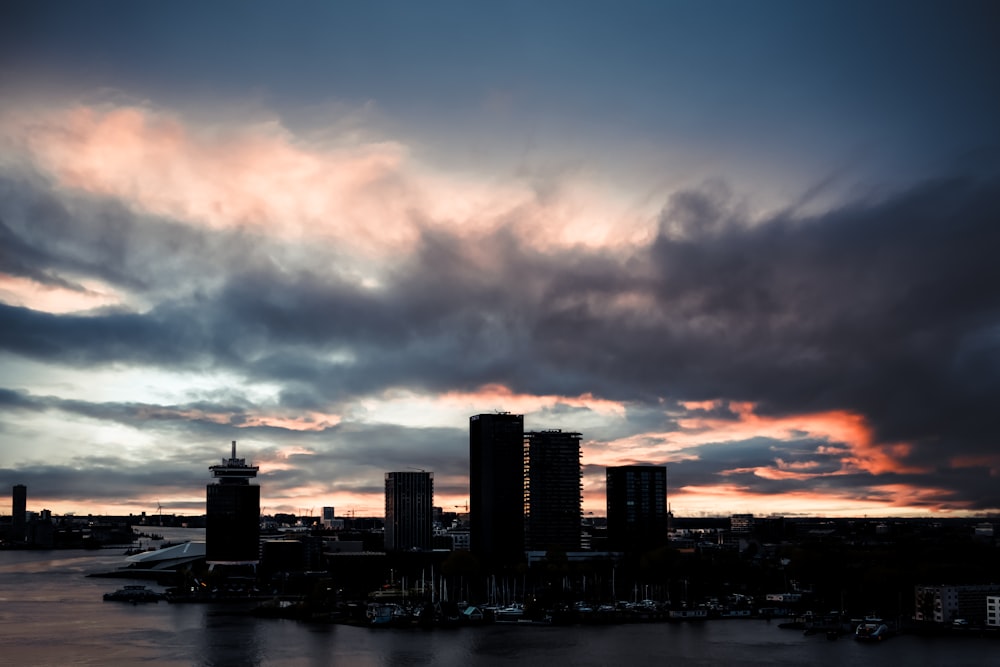 a cloudy sky over a city and a body of water