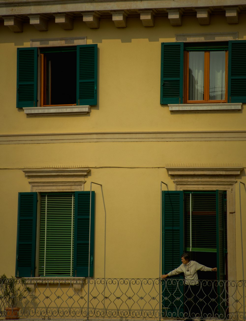 a man standing on a balcony next to a building