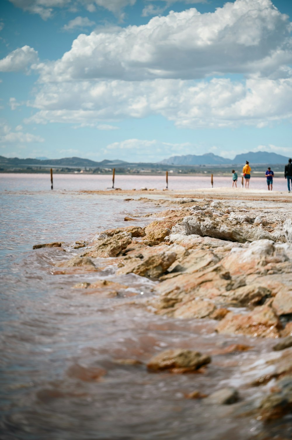 a group of people standing on top of a sandy beach