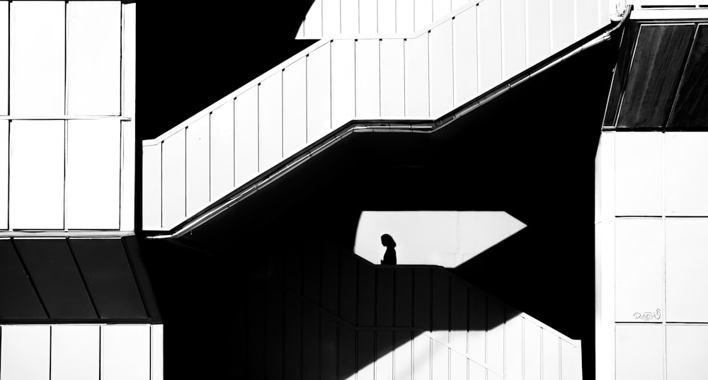 a black and white photo of a person walking up a set of stairs
