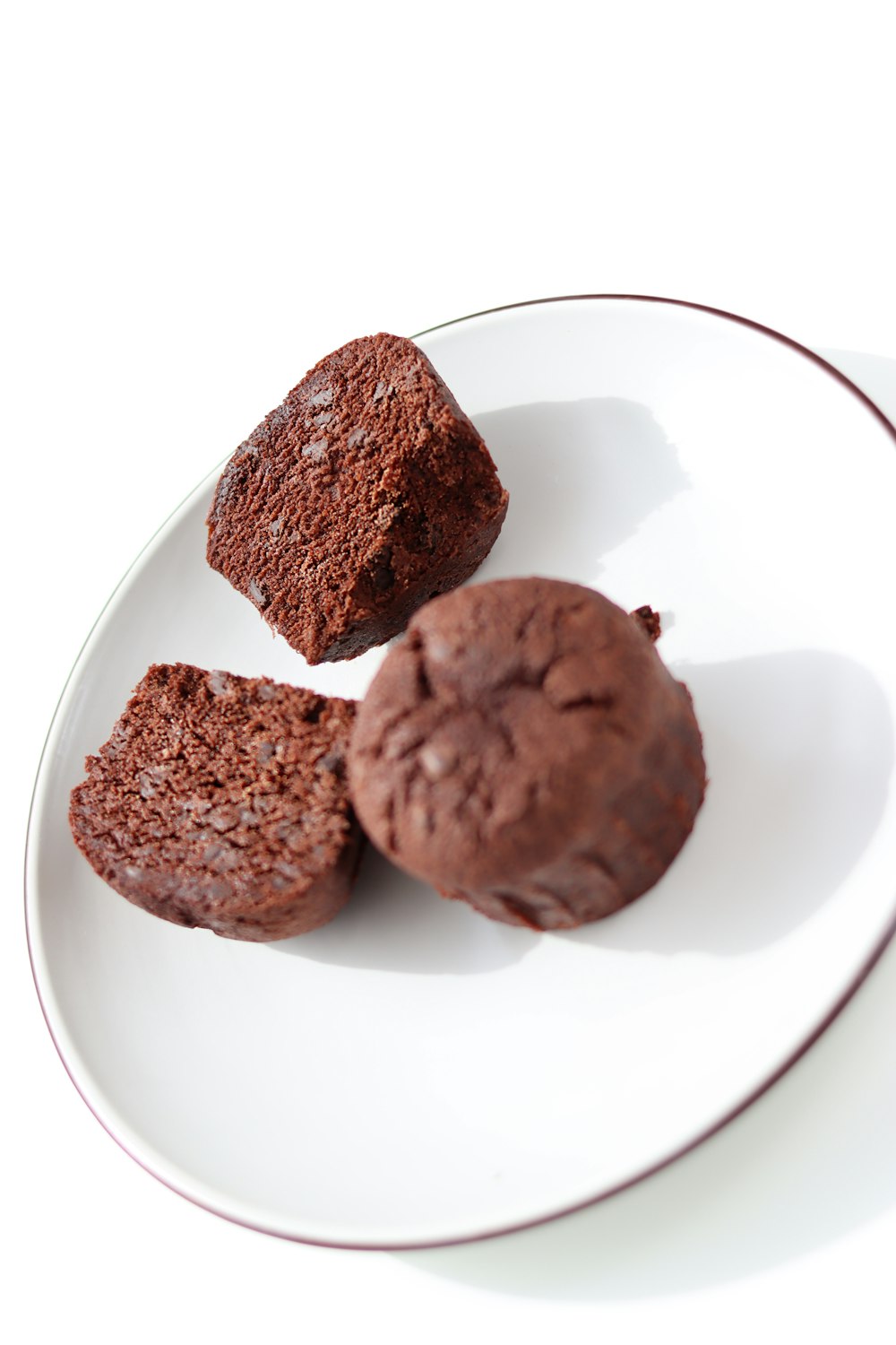 three chocolate muffins on a white plate