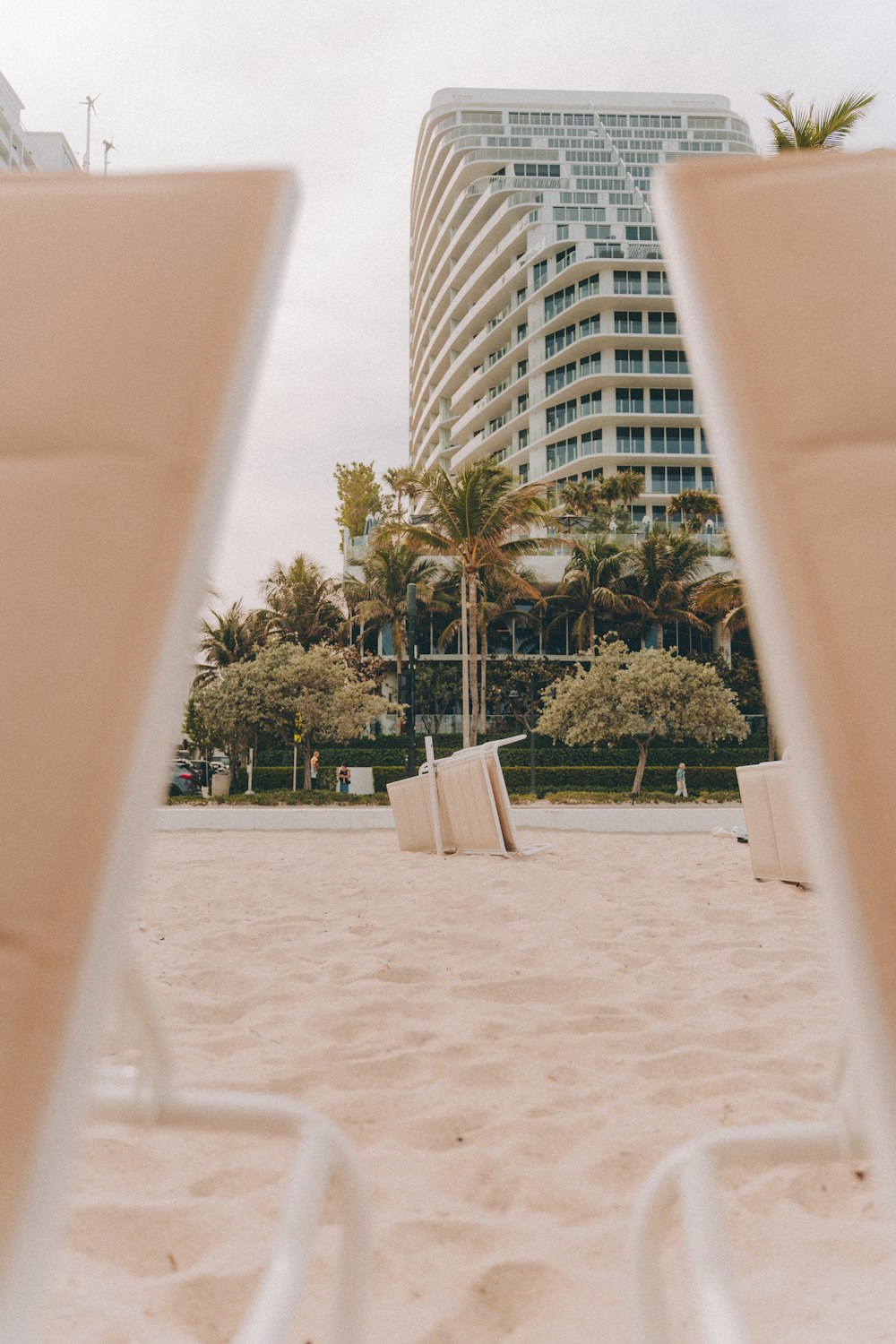 a couple of lawn chairs sitting on top of a sandy beach