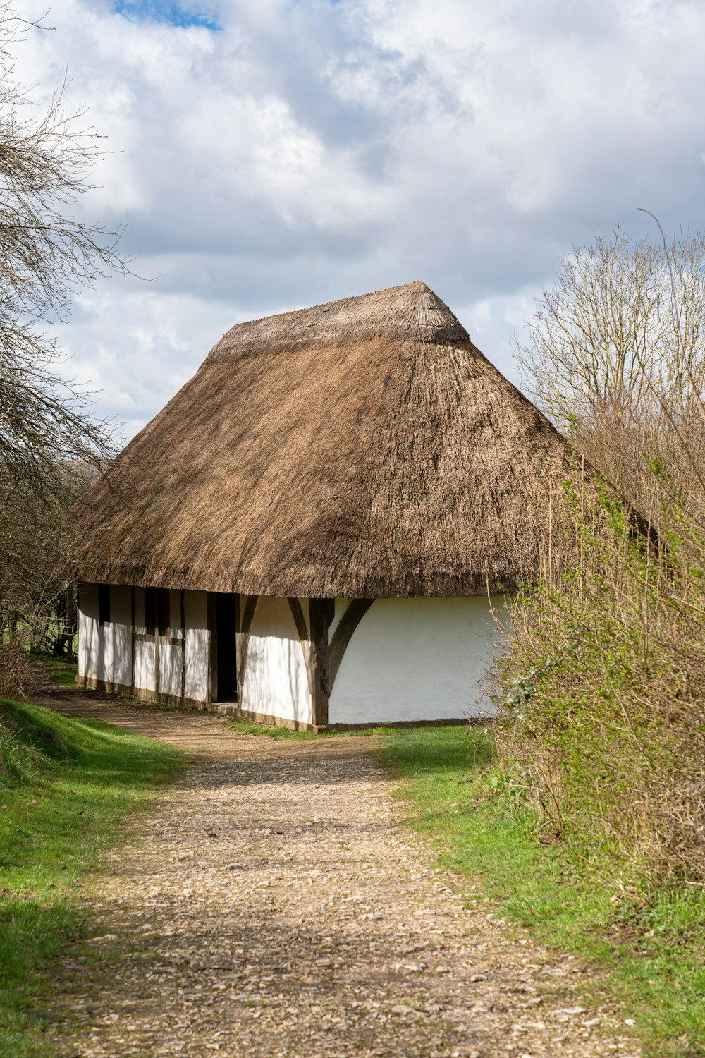 a thatched roof house with a path leading to it