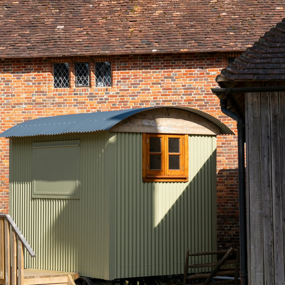 a small green building with a wooden door