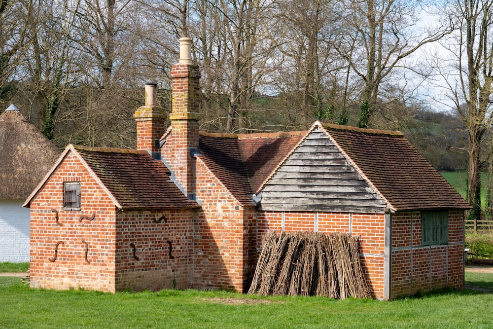 a brick building with a chimney in the middle of a field