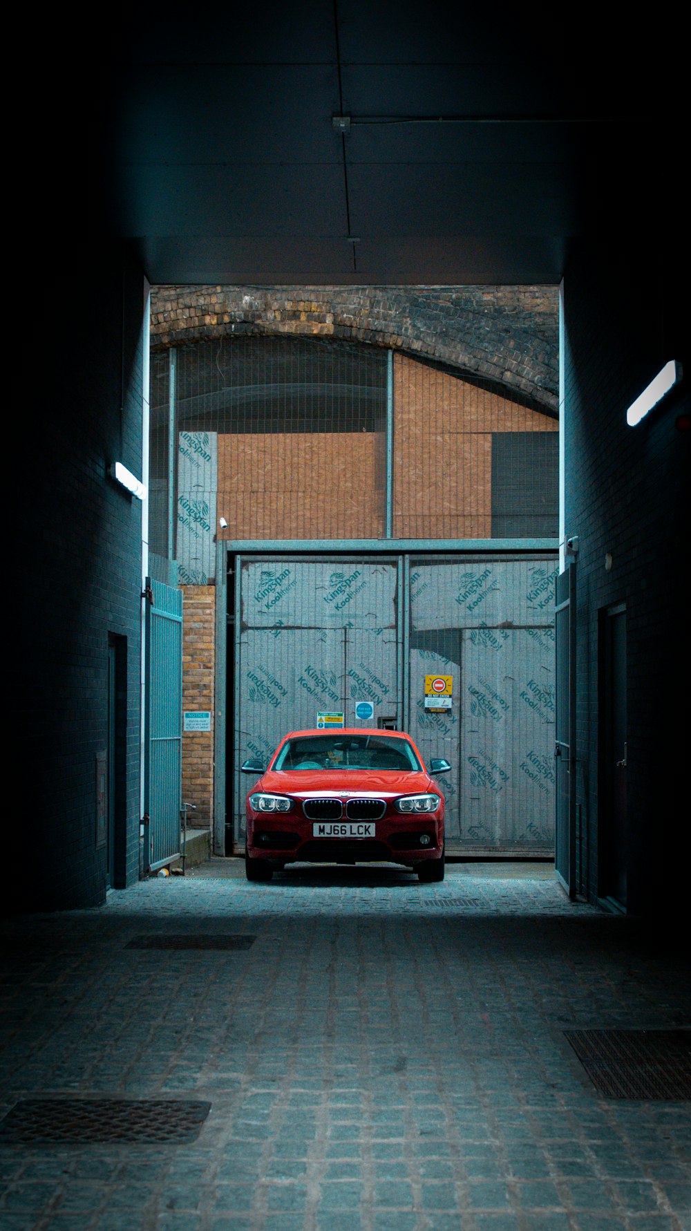 a red car is parked in an alley