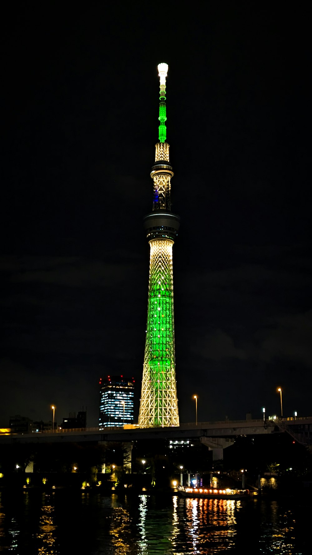 a very tall tower with a green light on it's side