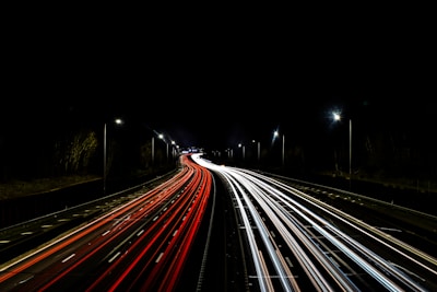 a long exposure photo of a highway at night