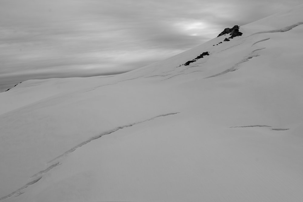 a man riding skis down the side of a snow covered slope