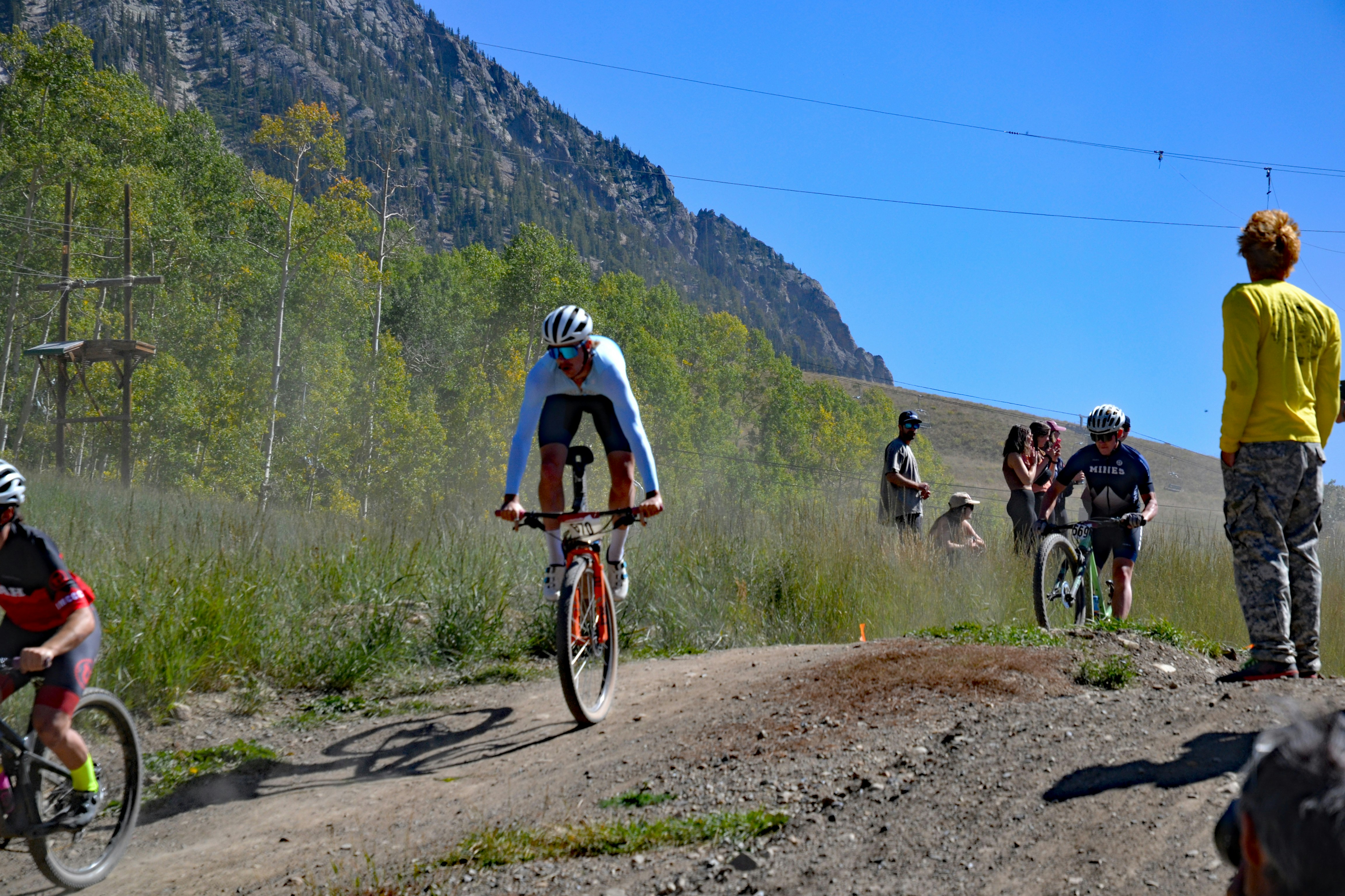 a group of people riding bikes down a dirt road
