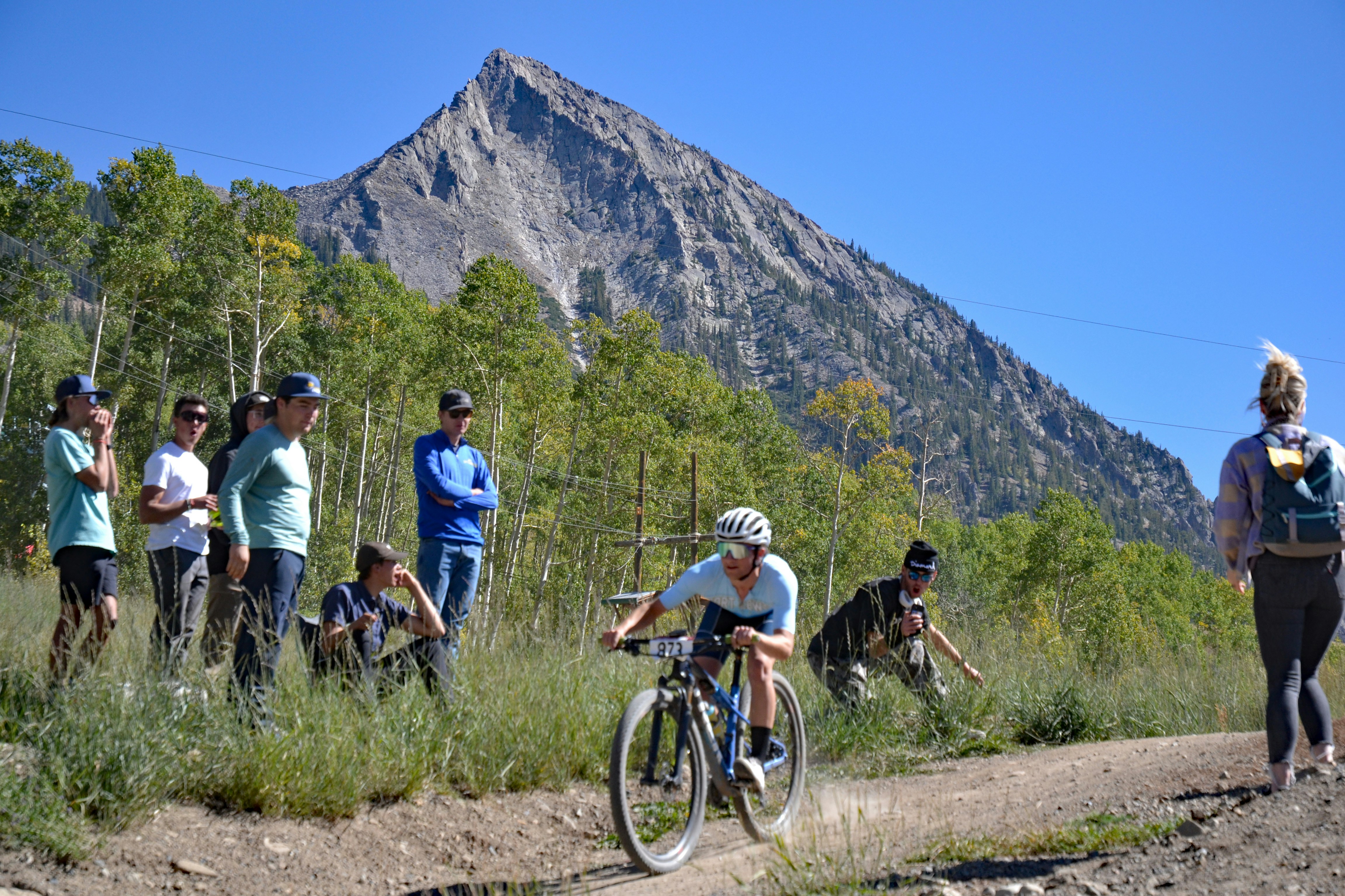 a man riding a bike down a dirt road