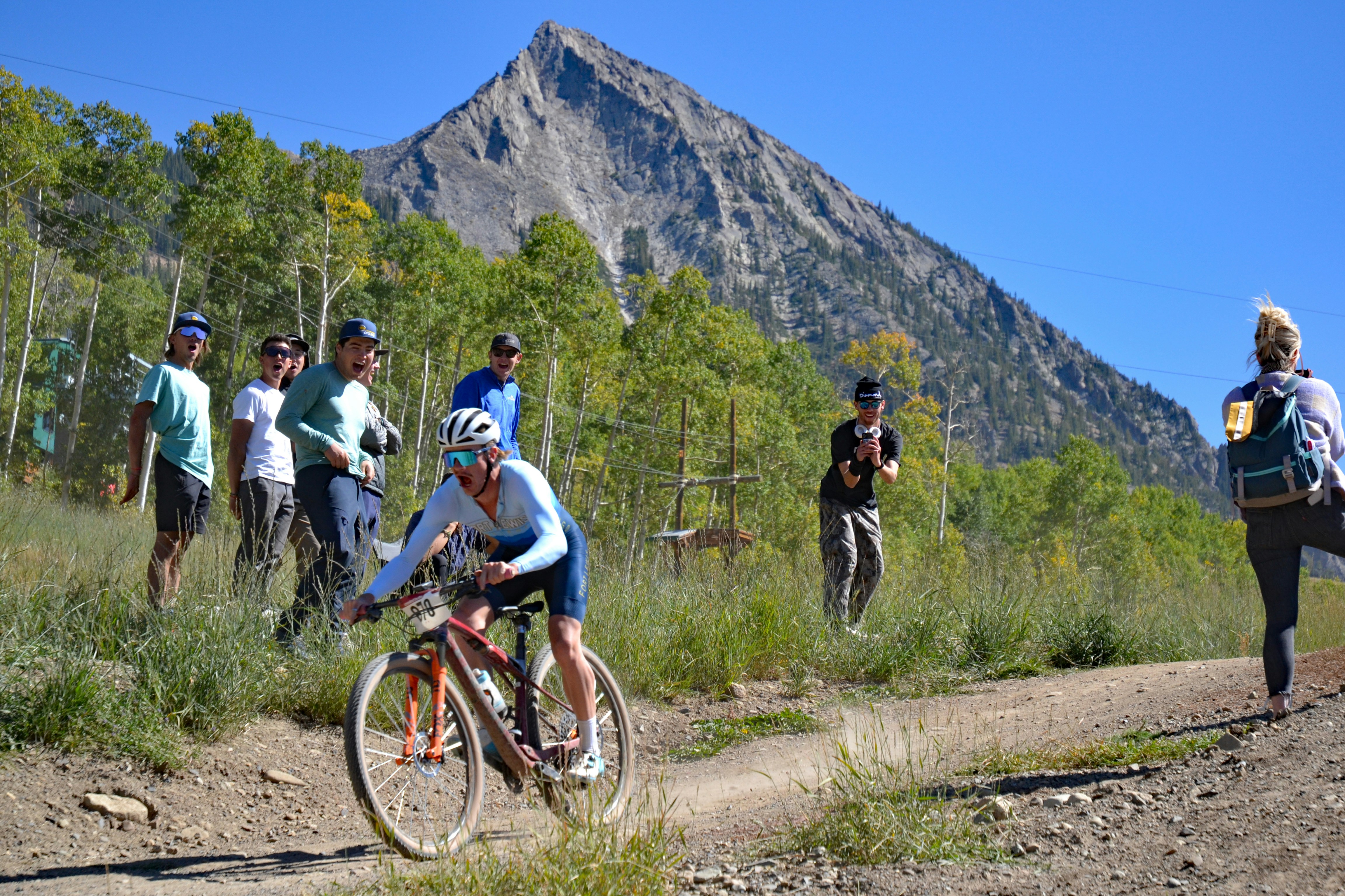 a man riding a bike down a dirt road